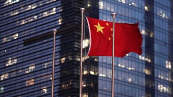 The Chinese national flag is flown in front of an office building.
