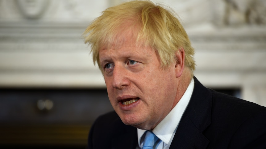 Boris Johnson speaks. He has a serious expression on his face.