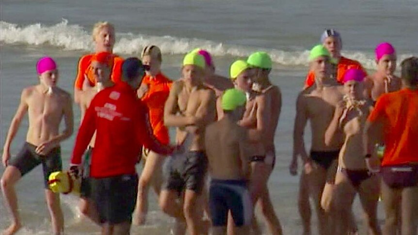 Young competitors from the national surf life saving titles leave the water on Kurrawa Beach