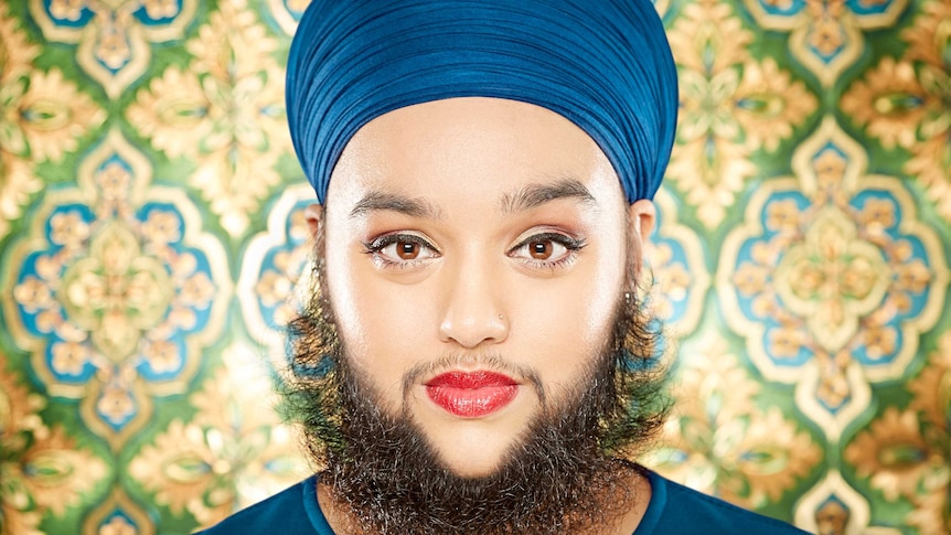 Harnaam Kaur stares at the camera in front of a colourful background