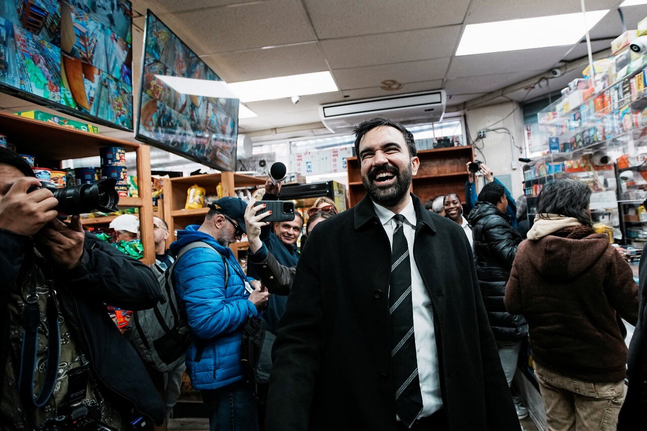 A man smiling and looking on in a busy cafe