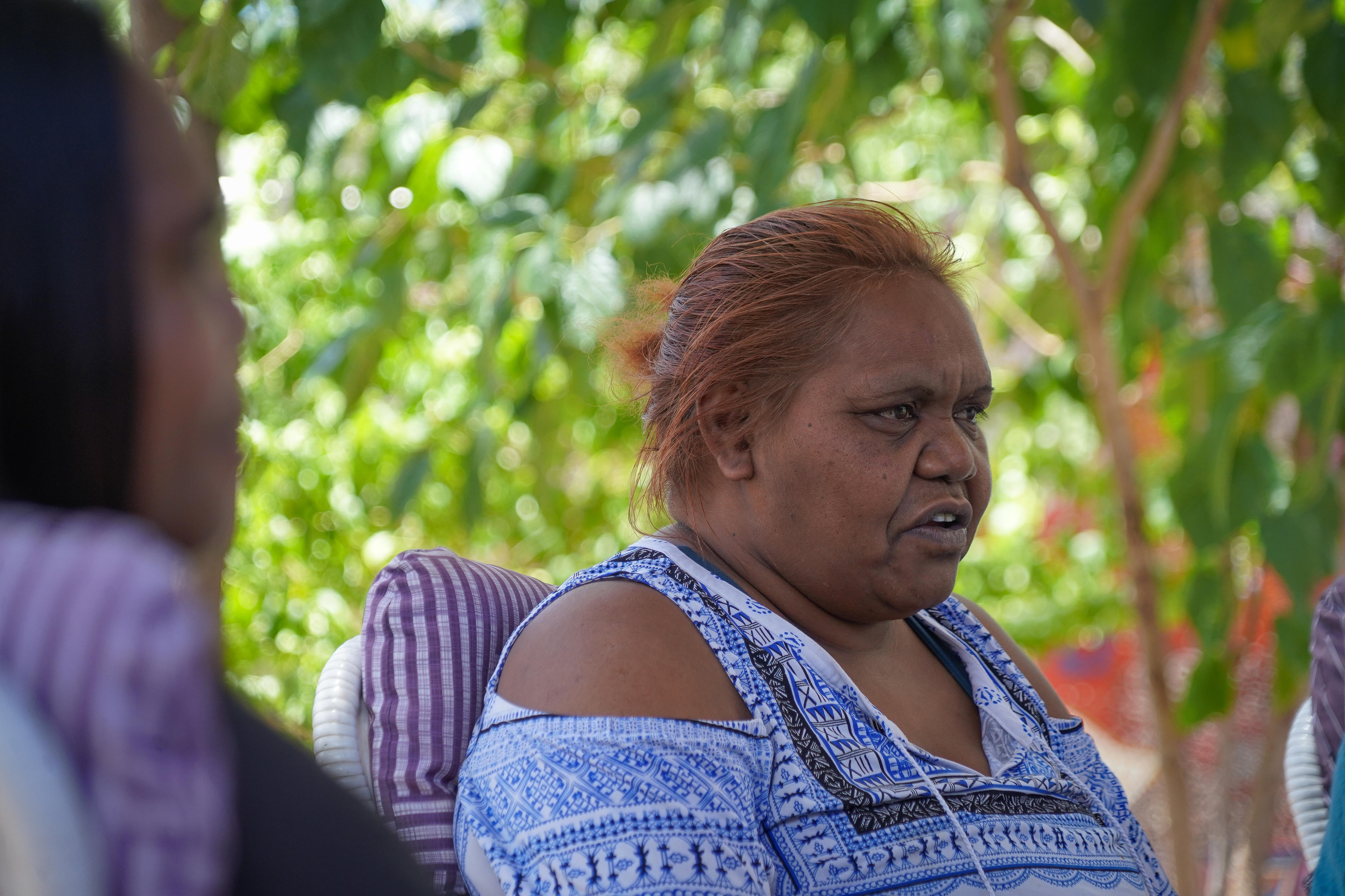 An Aboriginal woman in front of a tree