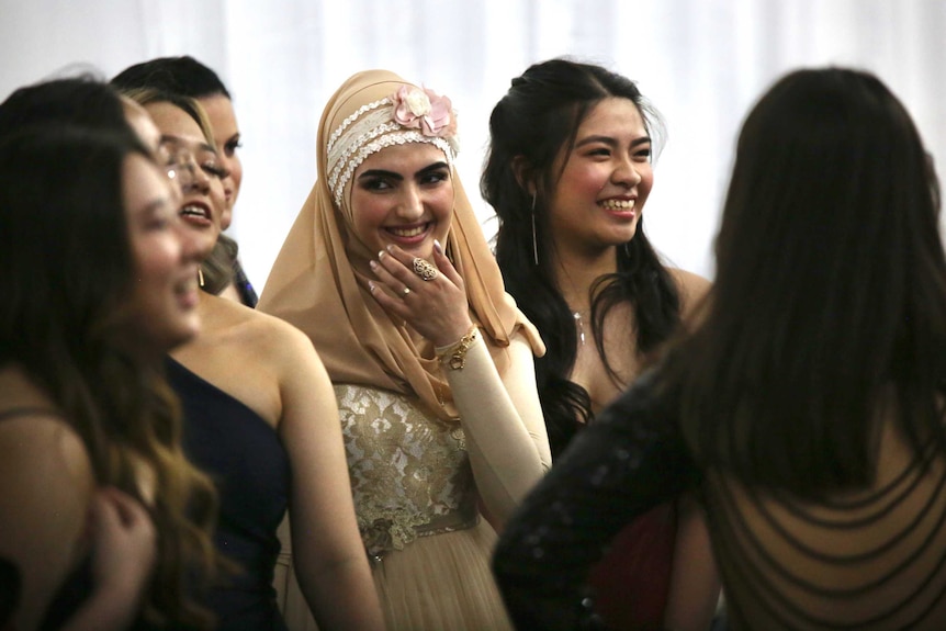 A group of women talk and smile