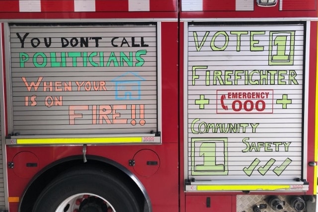 Camión de bomberos con eslogan que dice que no llames a los políticos cuando tu casa está en llamas.