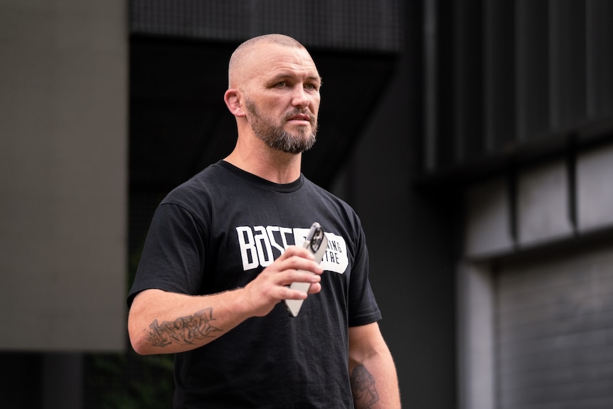 A man in a black shirt looking intense. 