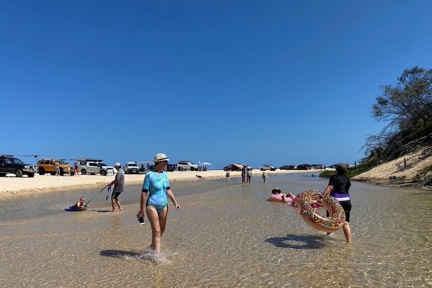 Visitors enjoy blue skies at Eli Creek on Fraser Island's eastern side.