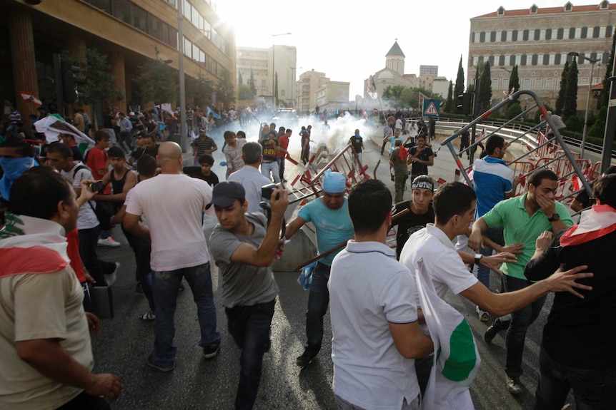 Lebanese policemen fire tear gas during clashes with angry mourners in Beirut.