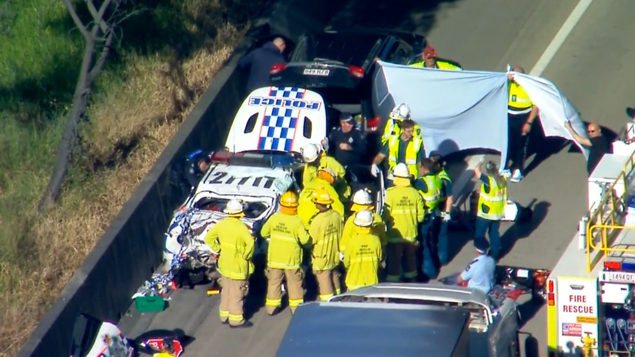 firefighters around a crashed police car on the M1