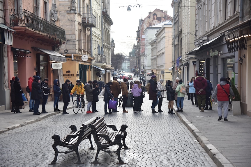 People queue at an ATM in Ukraine.