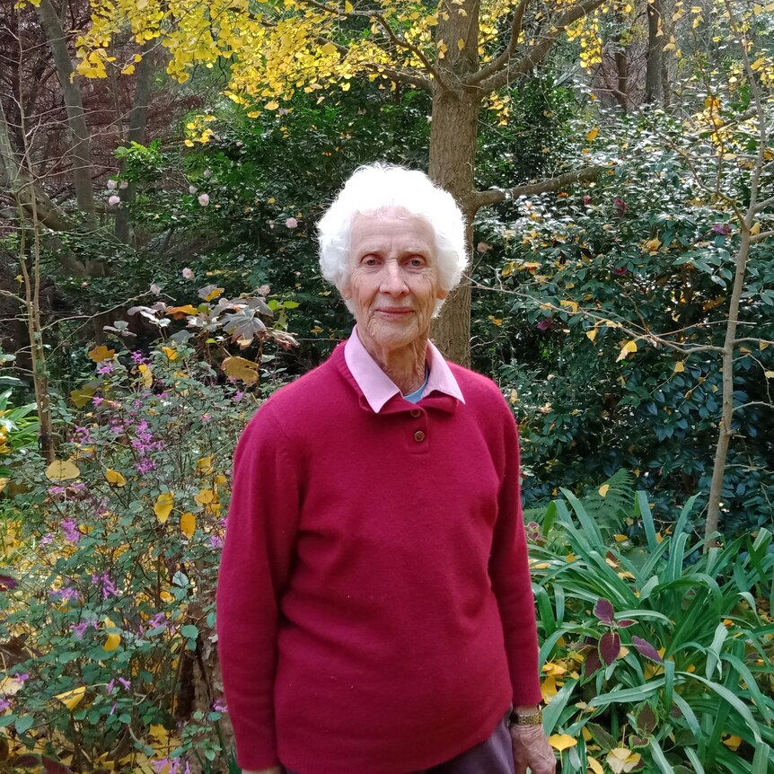 a woman standing in front of thick garden brush