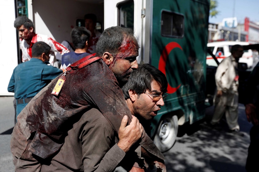 Afghan man carries an injured man to a hospital after a blast in Kabul, Afghanistan May 31, 2017.
