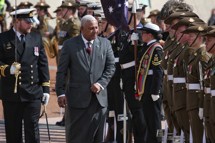Mr Bainimarama walks past an artillery salute with soldiers dressed in Australian army uniforms in Canberra.