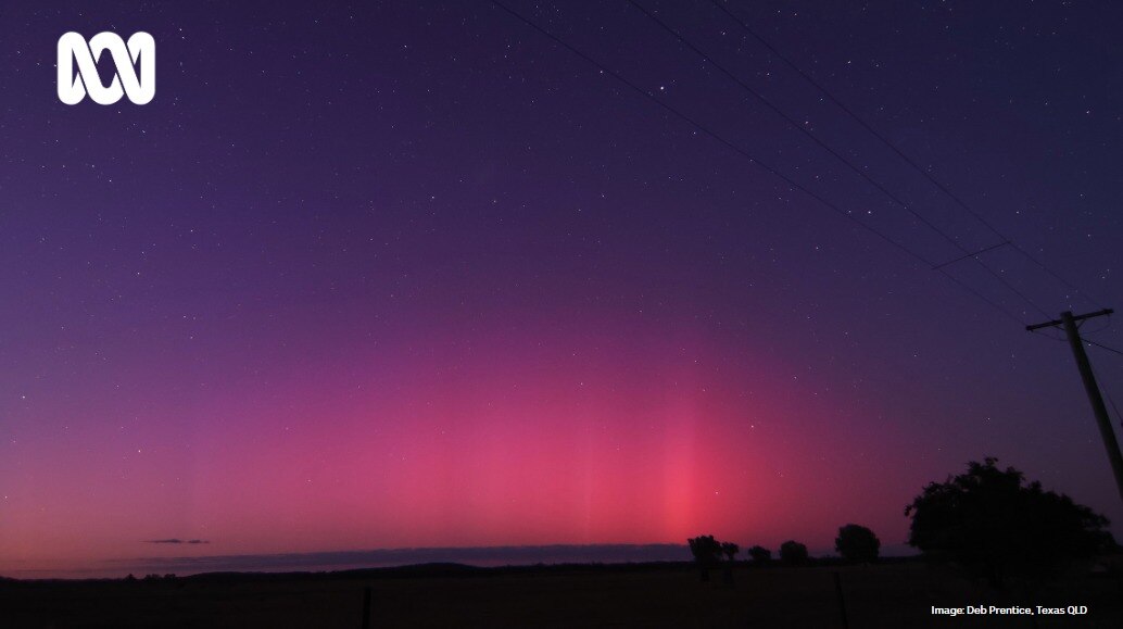 A pink and purple aurora australis in the night sky