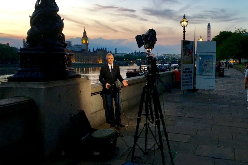 Speers standing in front of camera by river Thames in London with Big Ben in the background.