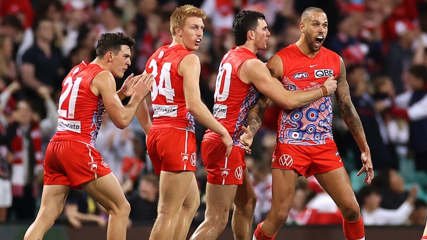 Lance Franklin is surrounded by Swans teammates as he yells