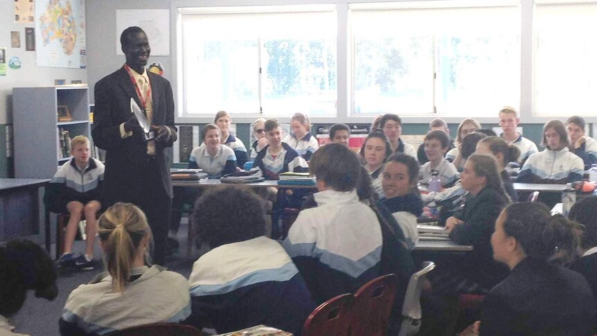 A man stands in front of a classroom of students