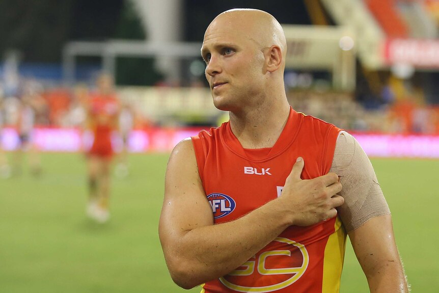 Gary Ablett reaches for his injured shoulder