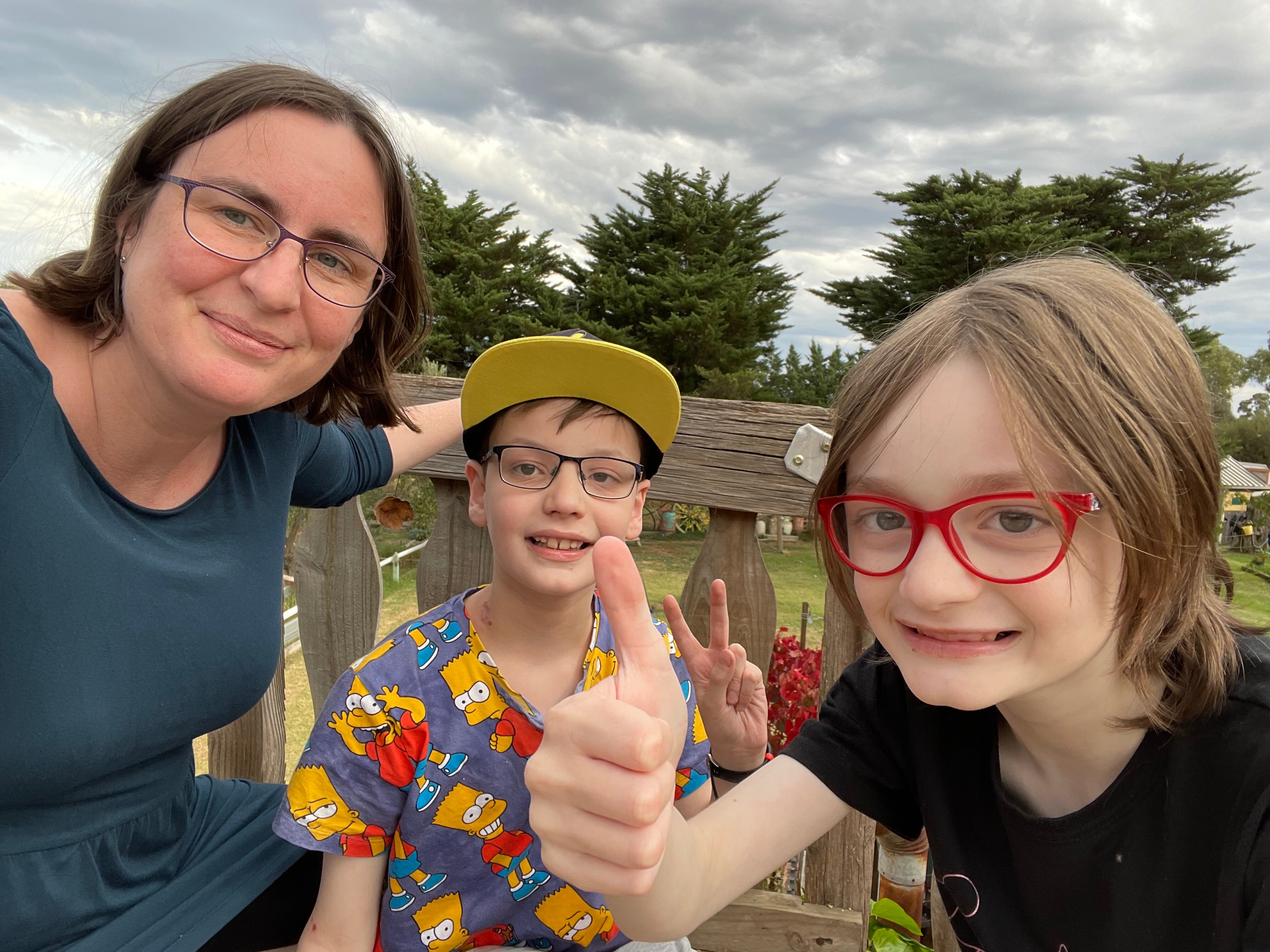 A young white woman with her two young kids. Both are smiling