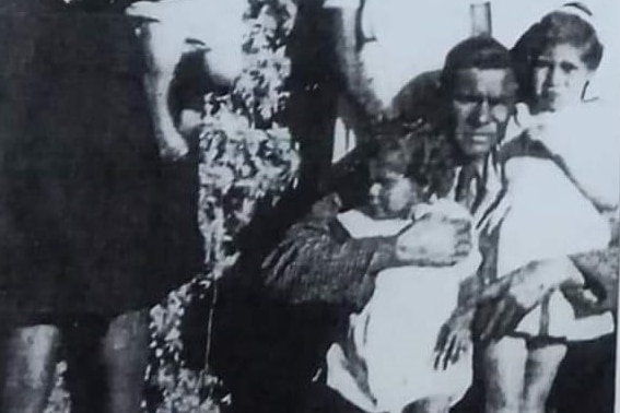 A black and white family portrait, with a man, woman and four children.