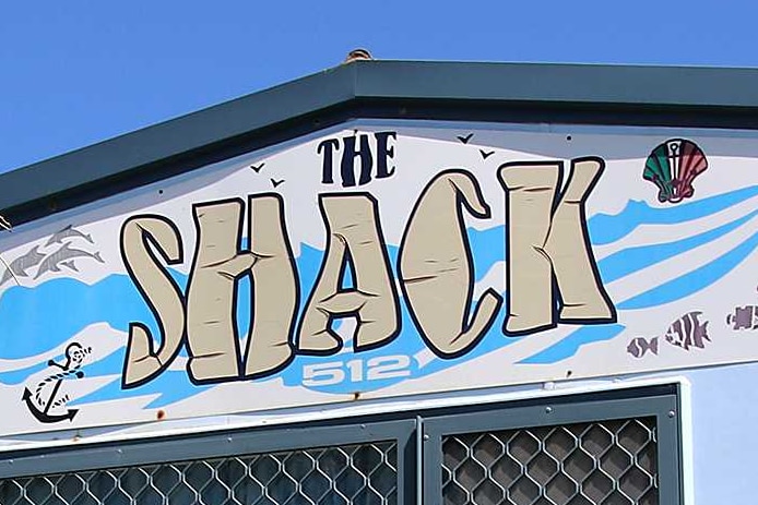 A beach shack with a big sign that says "the shack".