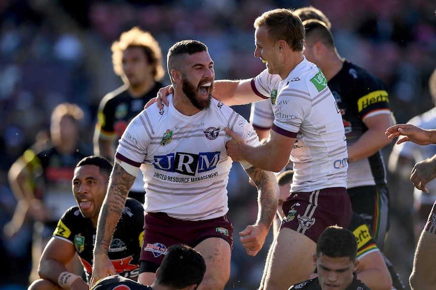 Manly players celebrate scoring a try against Penrith