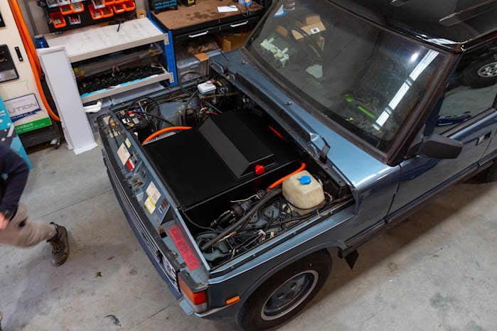 A shot from above of a 4WD with open bonnet showing electric motor