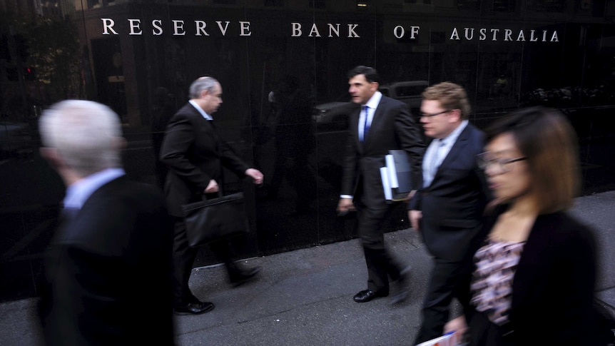 Business people walk outside the Reserve Bank of Australia.