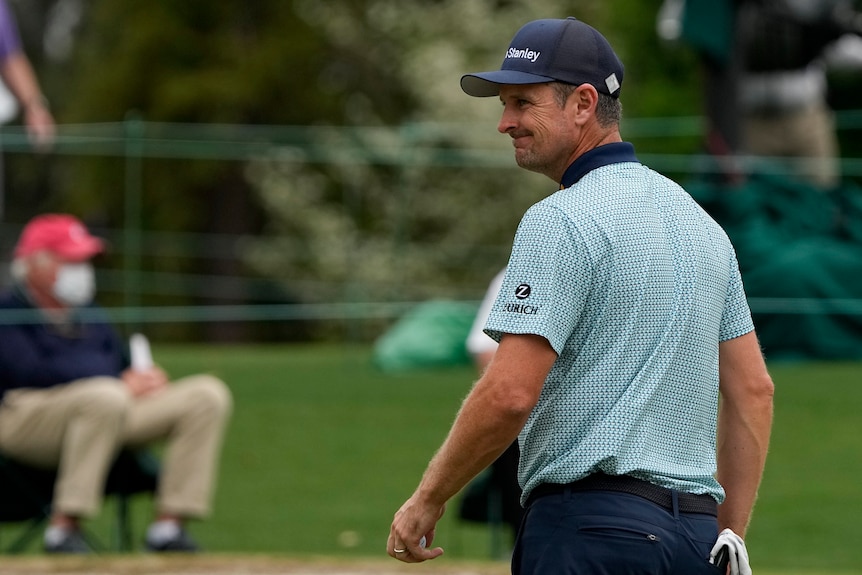 Justin Rose, of England, smiles after putting on the 18th green during the second round of the Masters golf tournament.