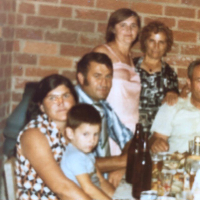 A man sits next to a woman and child.