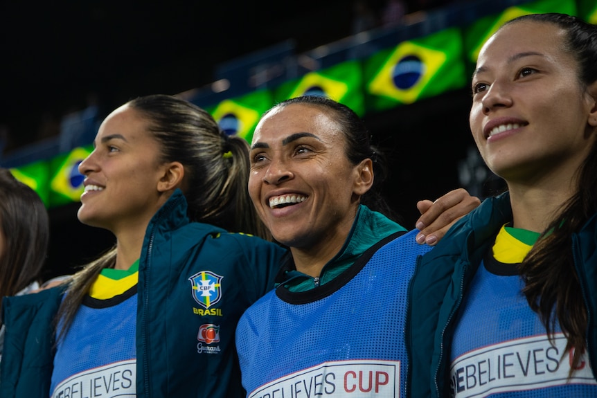 Three Brazilian players arm in arm smiling