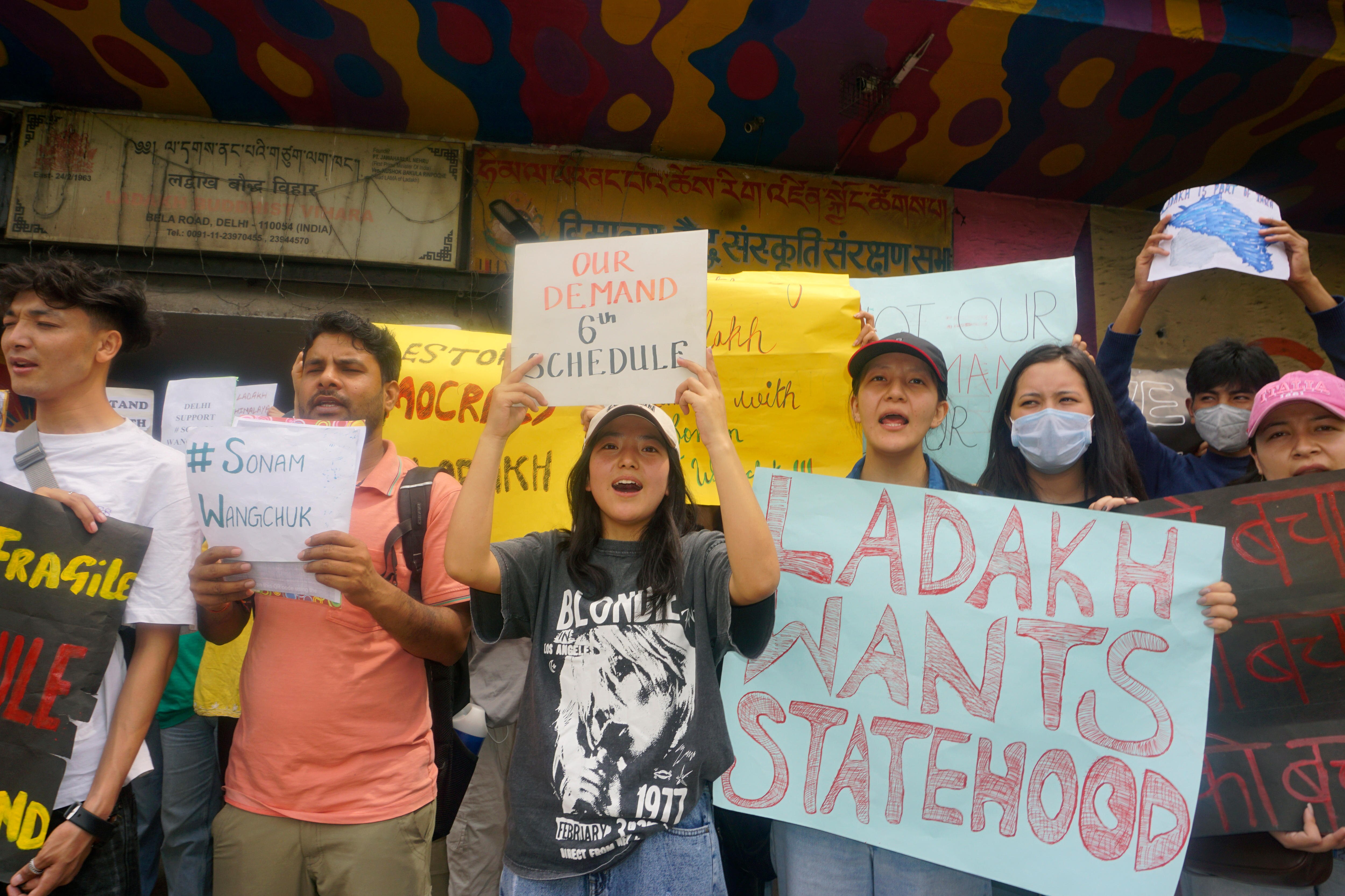 Protesters hold signs demanding statehood from the Indian government