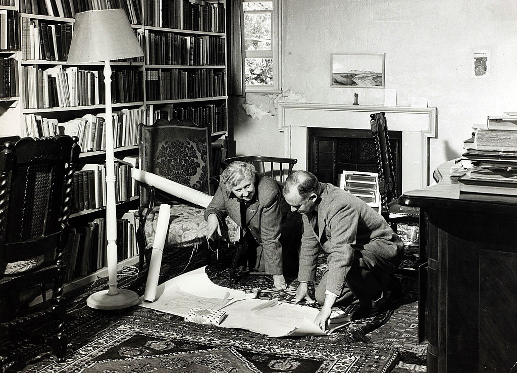 Agatha Christie  studies documents with her husband, archaeologist Max Mallowan (1904-1978), in a library in her home in 1946. 