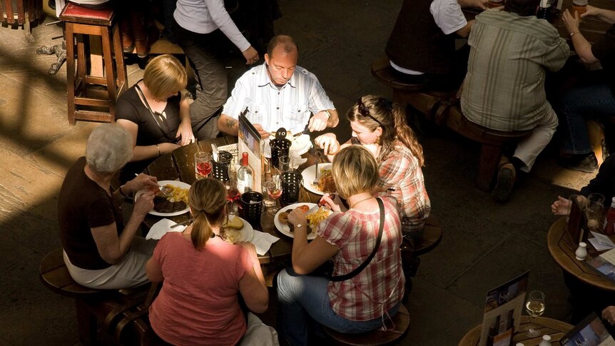 A family of six have a pub lunch at a circular table