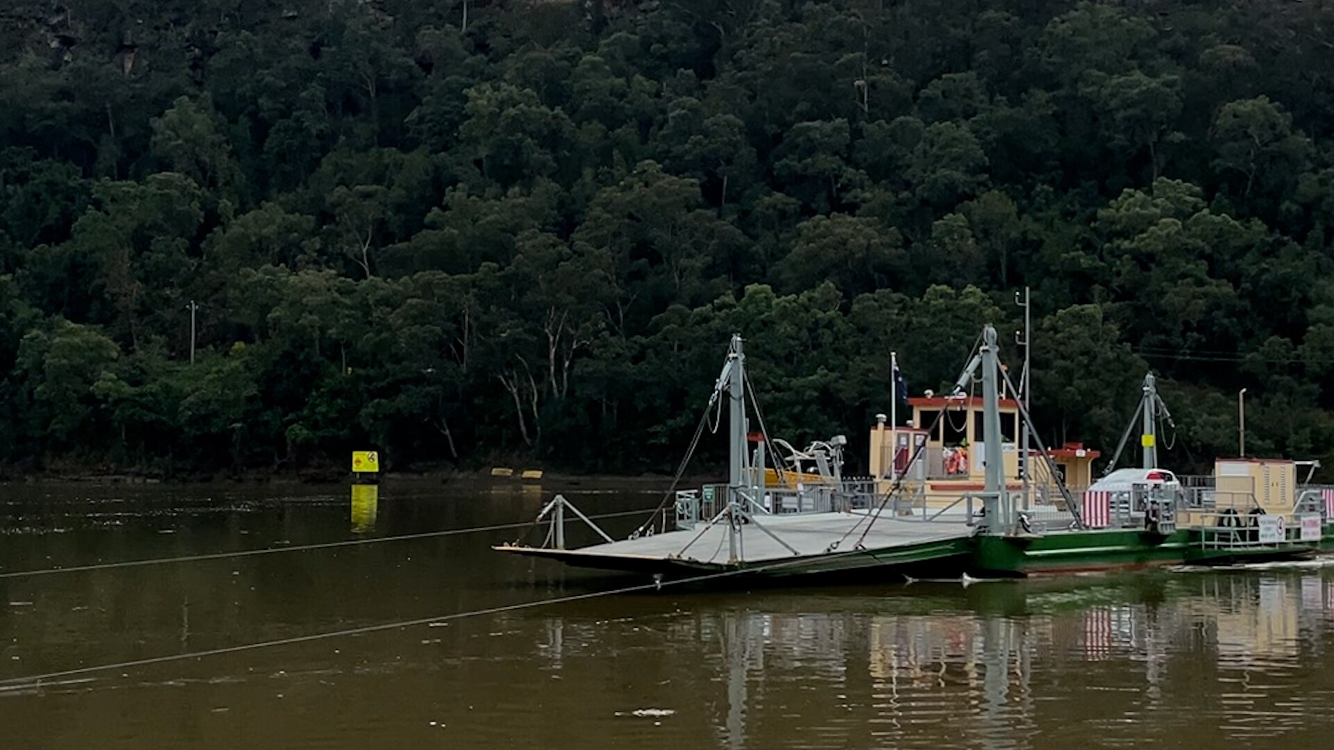 A wire-drawn boat carrying cars on a river