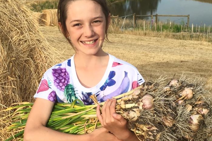 Girl carrying garlic, promotional image for Koonya Garlic Festival.