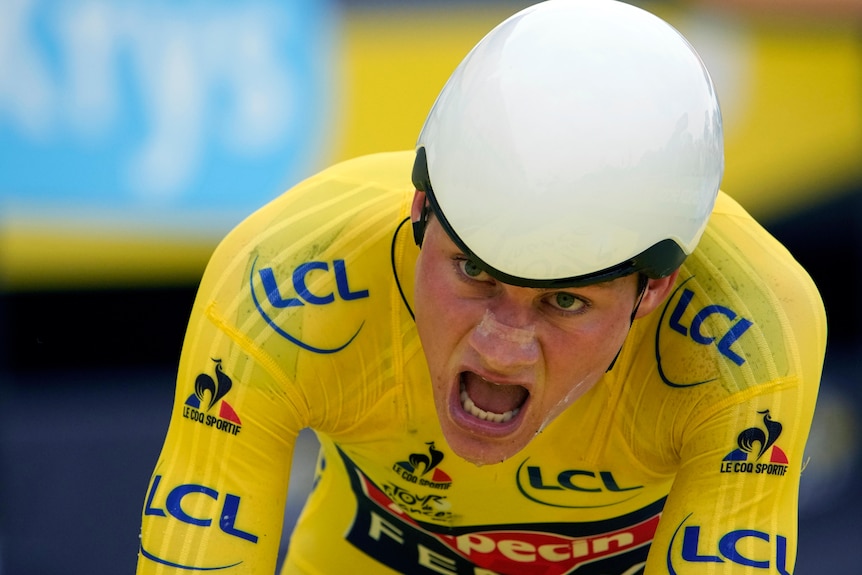 Mathieu Van Der Poel rides with his mouth open, wearing a yellow skin suit