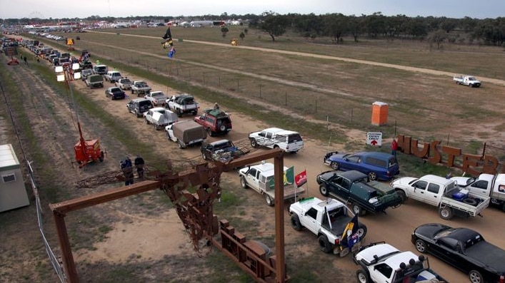 A line of utes entering a gate.