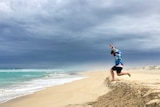 A young boy leaps off a small sand dune on Gunya Beach on the Eyre Peninsula, SA.