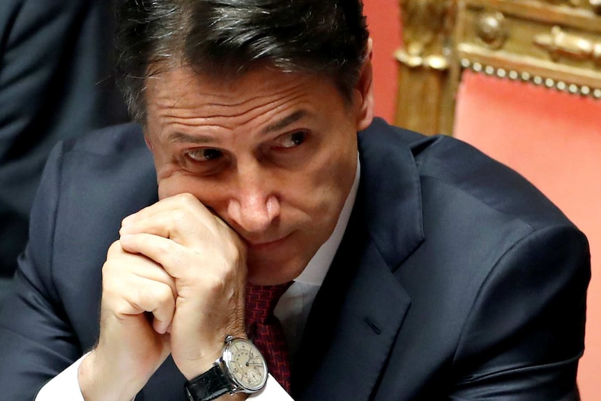 Italian Prime Minister Giuseppe Conte sits in parliament with his hands clasped.