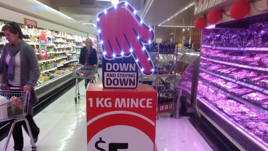 Shoppers in a Coles supermarket aisle.