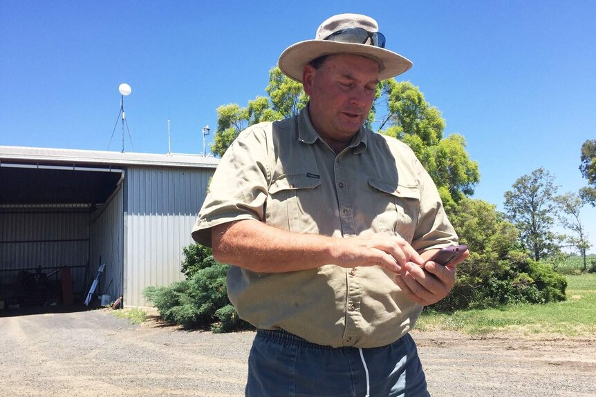 Kim Bremner using his smart phone on his farm at Bowenville near Dalby