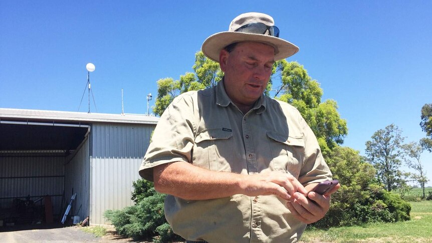 Kim Bremner using his smart phone on his farm at Bowenville near Dalby