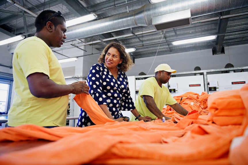 Leanne Liddle smiles as she listens to male inmate Shanston Charilie inside an industrial prison laundry.