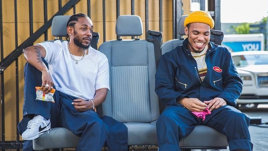 Kendrick Lamar and Anderson .Paak seated on car seats