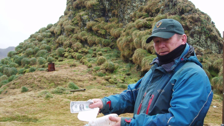 Parks and Wildlife employee Chris Howard with a bottle which contained a message from sailors off South Africa.