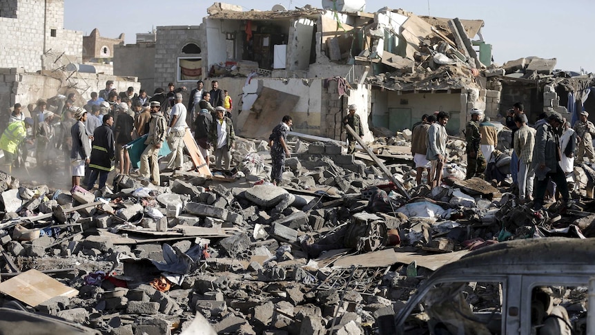 Civil defence workers and people search for survivors under the rubble of houses destroyed by an air strike