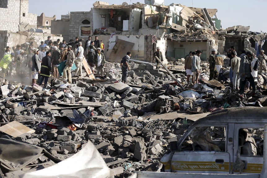 Civil defence workers and people search for survivors under the rubble of houses destroyed by an air strike