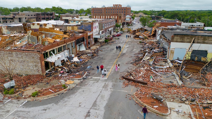 An aerial image shows a town main street filled with buildings destroyed by a tornado