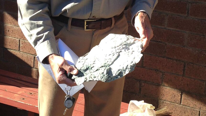 Geologost Max Rangott holding a piece of rock containing asbestos.