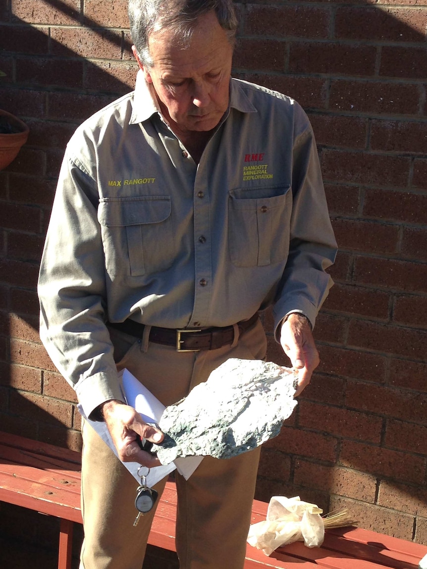 Geologost Max Rangott holding a piece of rock containing asbestos.